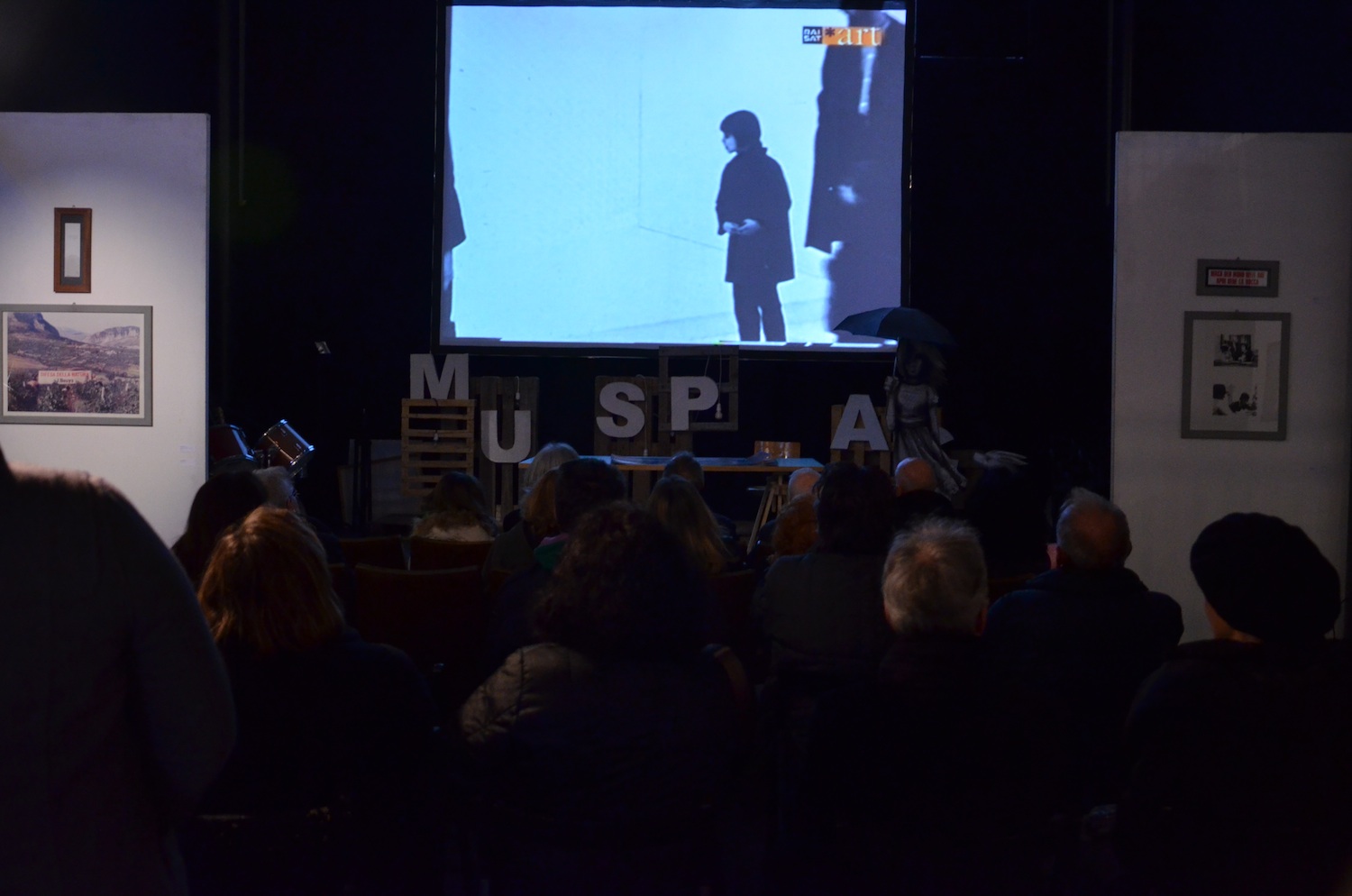 Il pubblico assiste alle proiezioni dei video sulla storia dell'Accademia